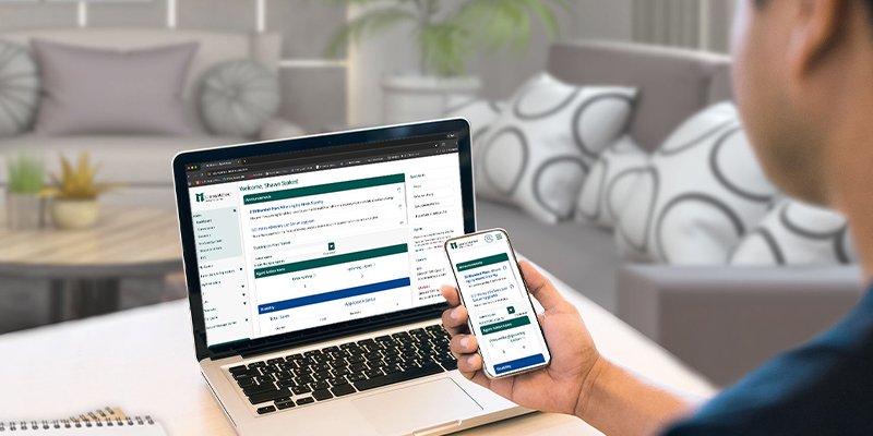 person looking at phone and laptop screens