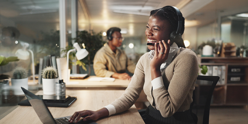 woman talking on the phone in front of laptop