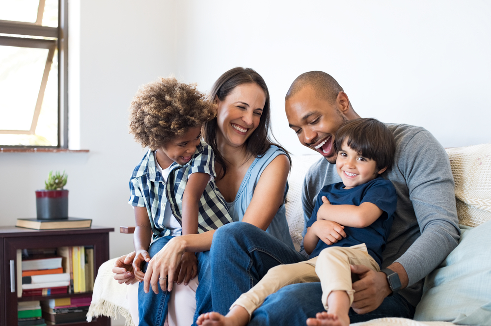 young family of four sitting on the couch