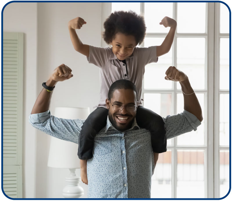grandfather with granddaughter on his shoulders outside