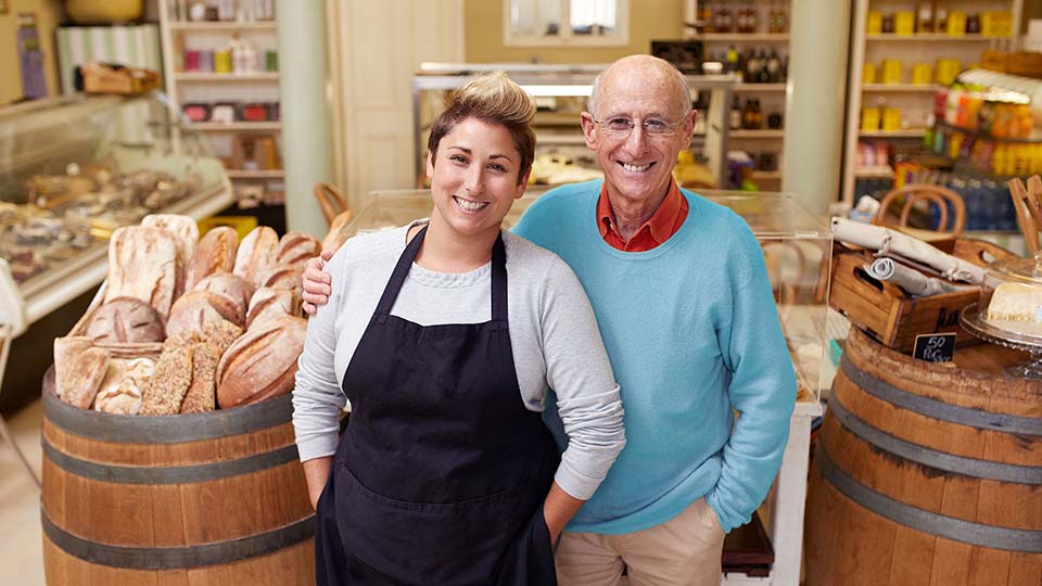 father and daughter small business owners standing together in their store