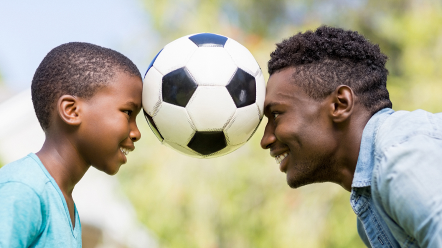 image of a father and son playing soccer
