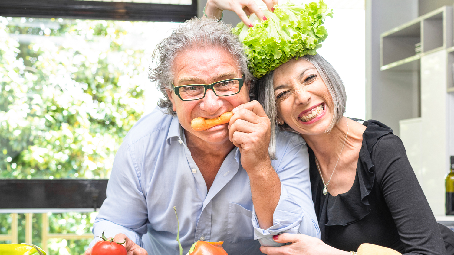 mature couple in the kitchen eating and smiling