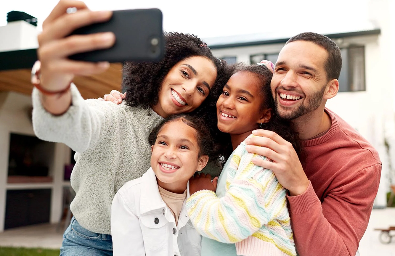 Family smiling and taking a selfie together