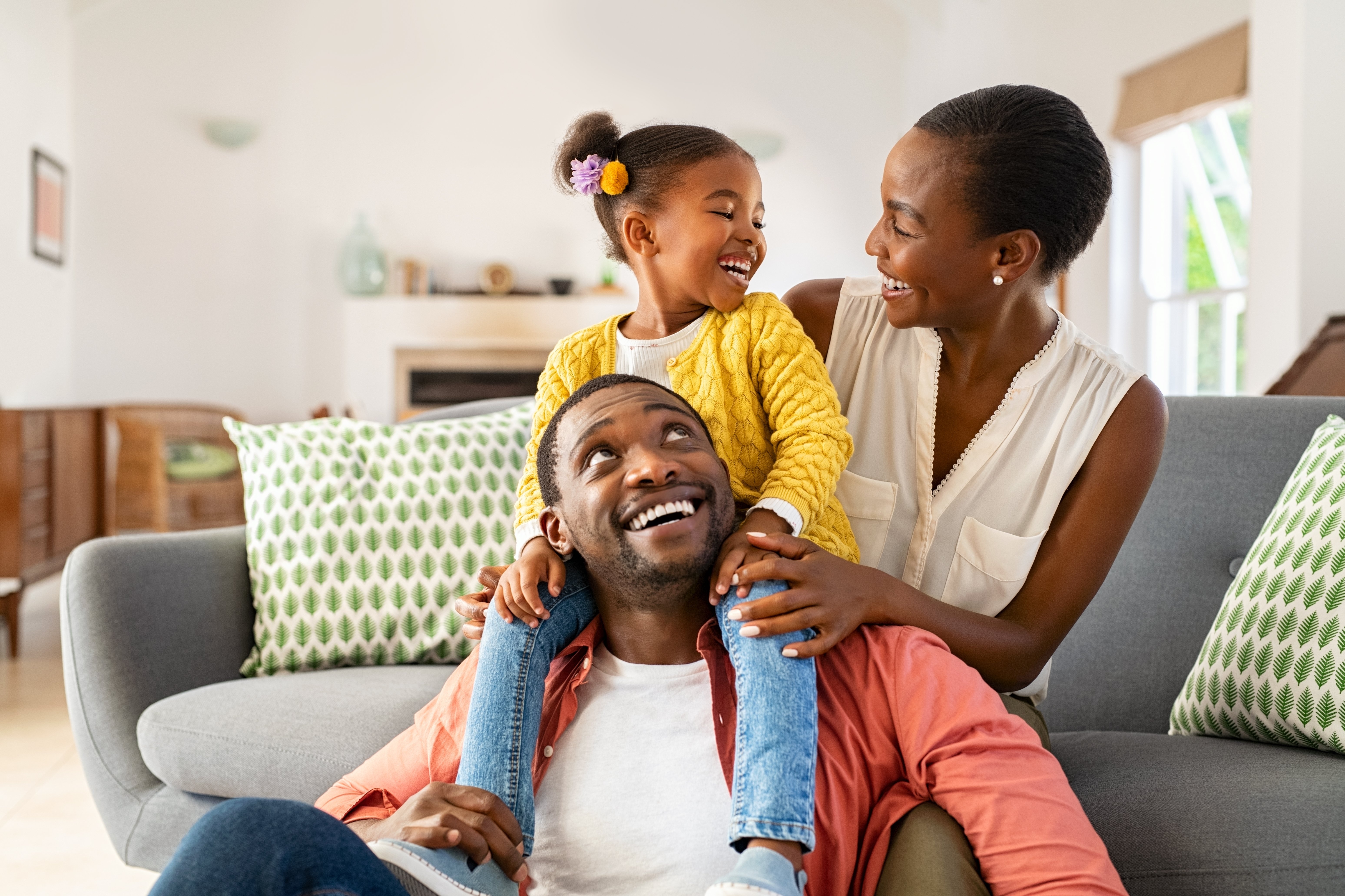 a family of three sitting in their living room