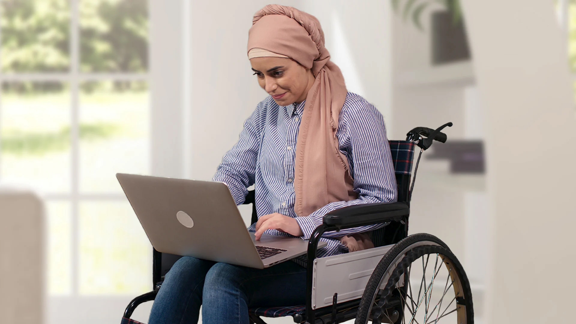 disabled woman in a wheelchair working on her laptop